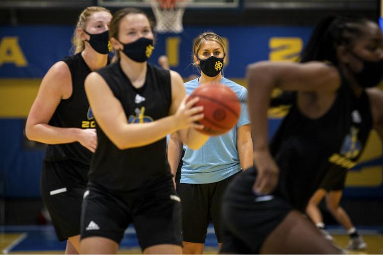 Masked women's basketball students playing